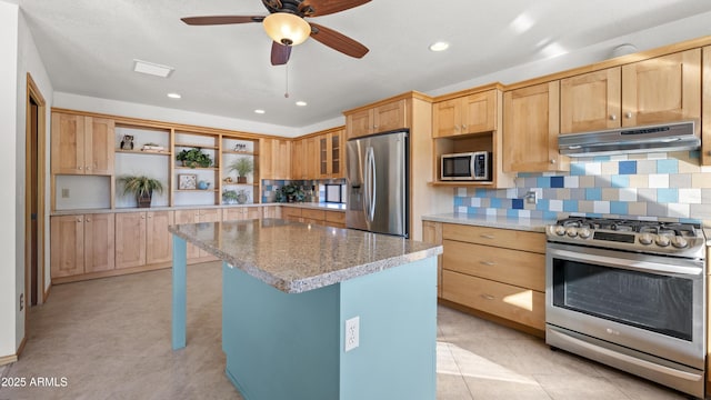 kitchen with a center island, ceiling fan, light stone countertops, tasteful backsplash, and stainless steel appliances