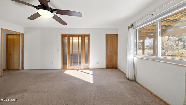 spare room featuring ceiling fan and light colored carpet