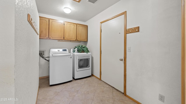 laundry area featuring washer and clothes dryer and cabinets