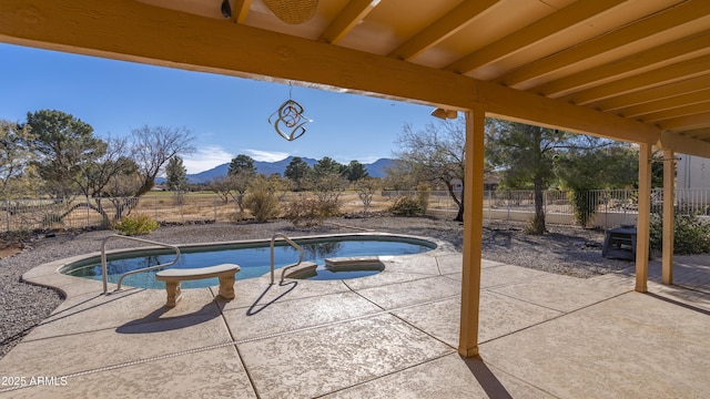 view of swimming pool with a mountain view, a patio area, and an outdoor hot tub