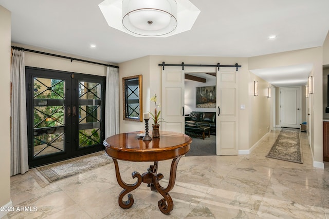 foyer with a barn door, light tile floors, and french doors