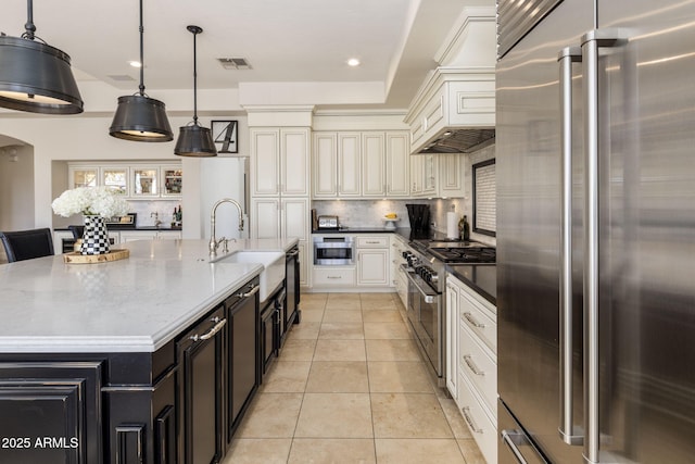 kitchen featuring premium appliances, a spacious island, backsplash, and hanging light fixtures