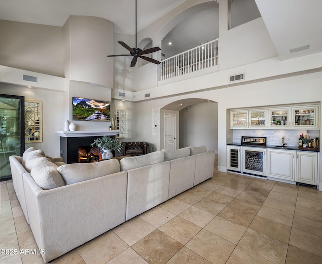 tiled living room featuring a high ceiling and ceiling fan