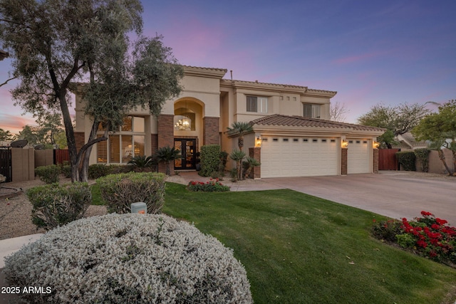 mediterranean / spanish home featuring a garage, french doors, and a lawn