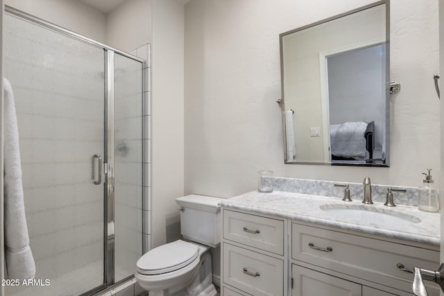 bathroom with toilet, a shower with shower door, and vanity