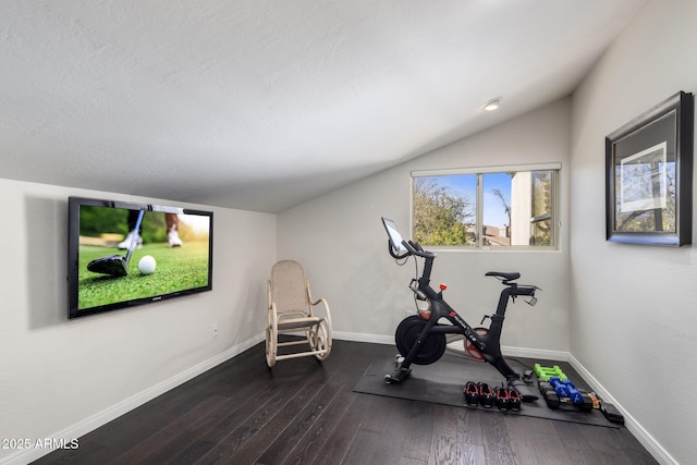 workout room featuring vaulted ceiling and dark hardwood / wood-style floors