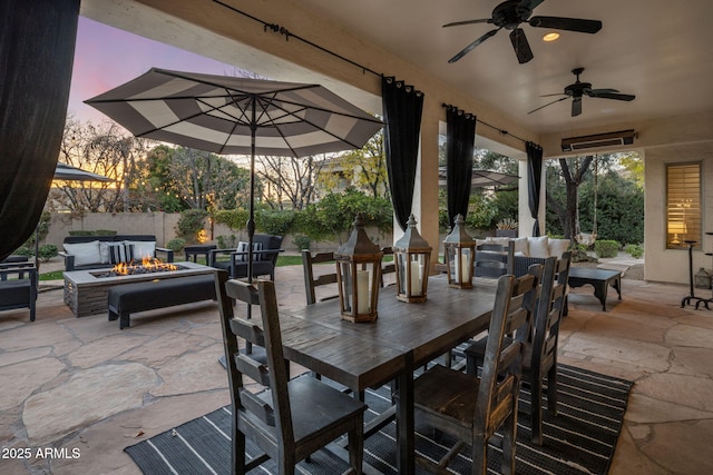 patio terrace at dusk with an outdoor fire pit and ceiling fan