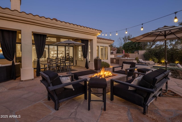 patio terrace at dusk featuring a fire pit