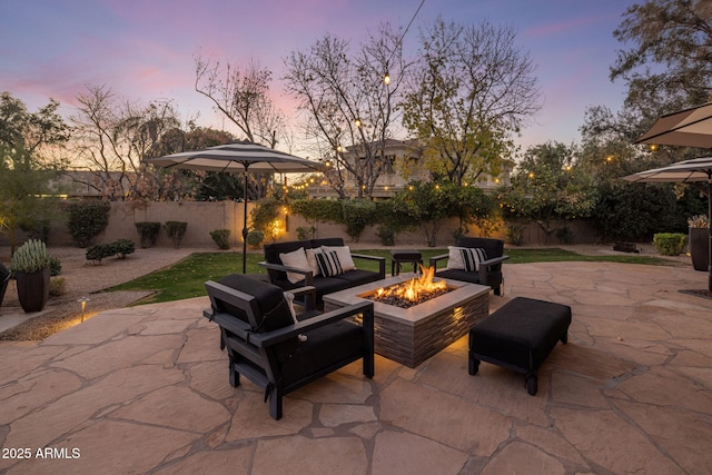 patio terrace at dusk featuring an outdoor living space with a fire pit