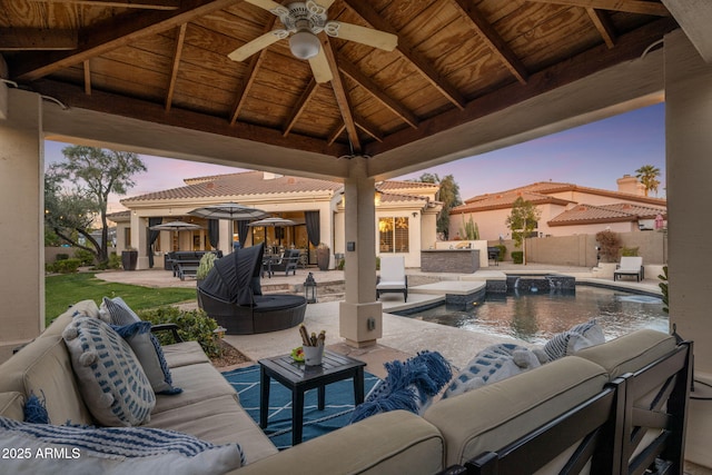 patio terrace at dusk with a gazebo, ceiling fan, and an outdoor living space