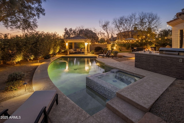 pool at dusk featuring area for grilling, a patio, a gazebo, a grill, and an in ground hot tub