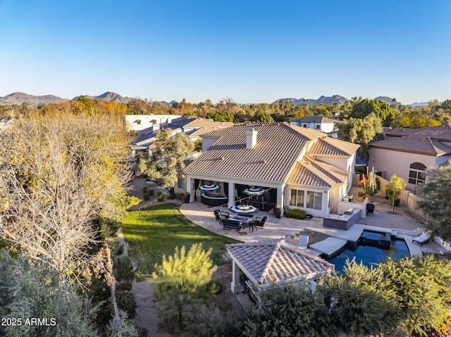 rear view of house featuring a lawn, a patio area, an outdoor living space, and a mountain view