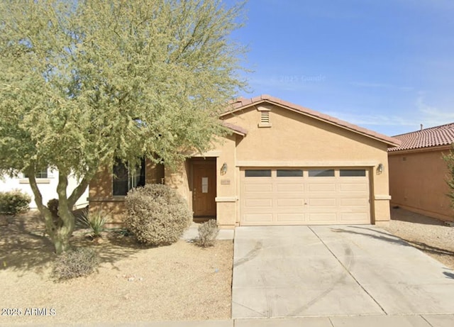 view of front facade with an attached garage, concrete driveway, stucco siding, and a tile roof