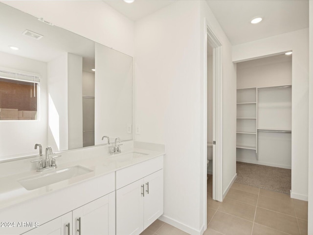 bathroom featuring toilet, tile patterned flooring, and vanity