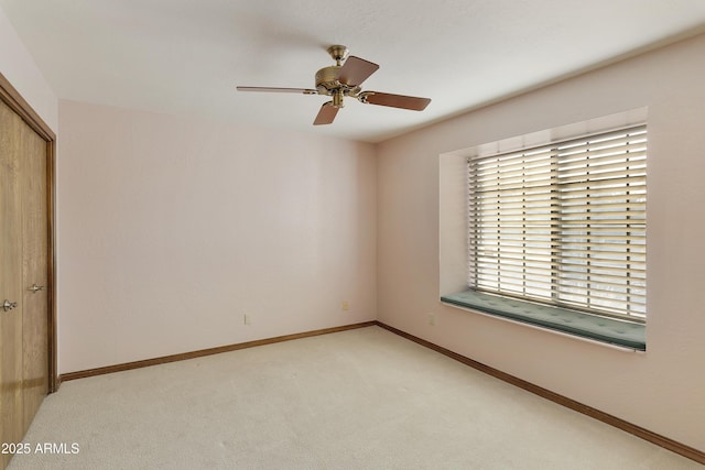 unfurnished bedroom featuring light carpet, ceiling fan, and a closet