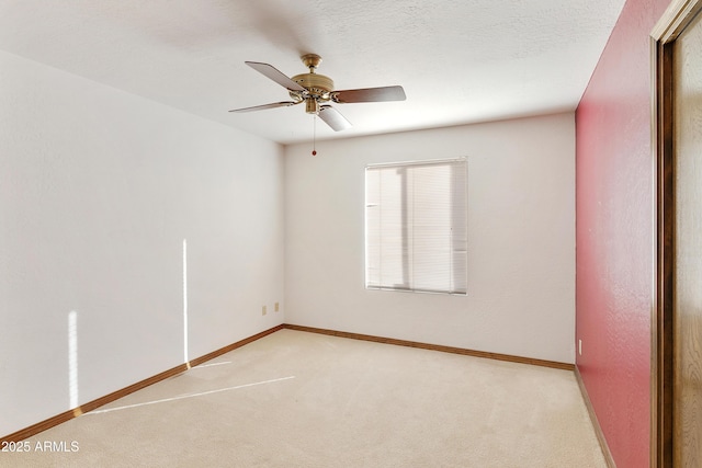 carpeted spare room featuring ceiling fan and a textured ceiling