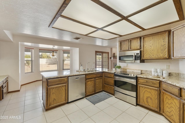 kitchen featuring a healthy amount of sunlight, appliances with stainless steel finishes, kitchen peninsula, and sink