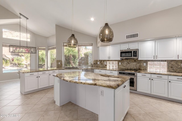 kitchen with appliances with stainless steel finishes, a kitchen island, and white cabinets