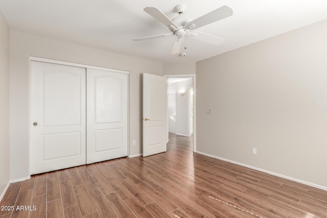 unfurnished bedroom featuring hardwood / wood-style flooring, ceiling fan, and a closet