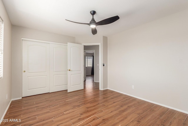 unfurnished bedroom with ceiling fan, a closet, and light hardwood / wood-style floors