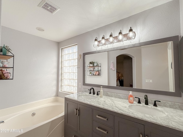 full bath with a bath, double vanity, visible vents, and a sink