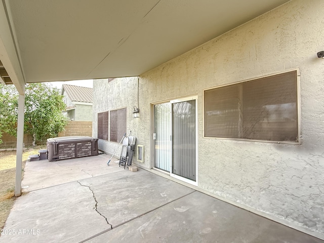 view of patio with fence, a hot tub, and central AC unit