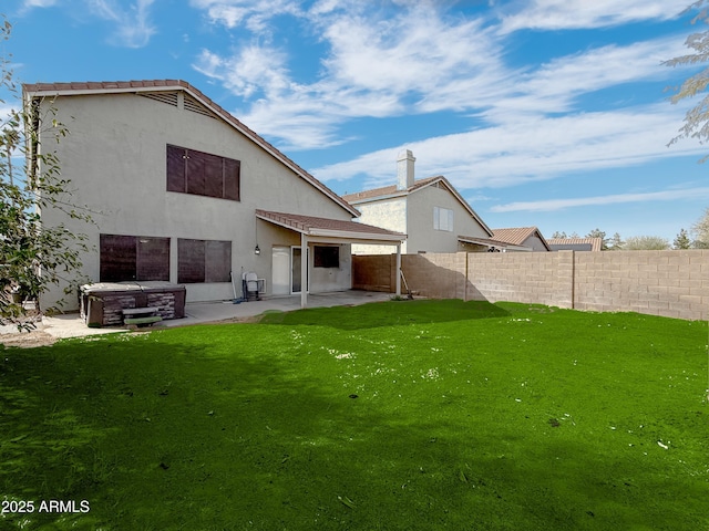 back of house featuring a patio area, a fenced backyard, stucco siding, and a yard