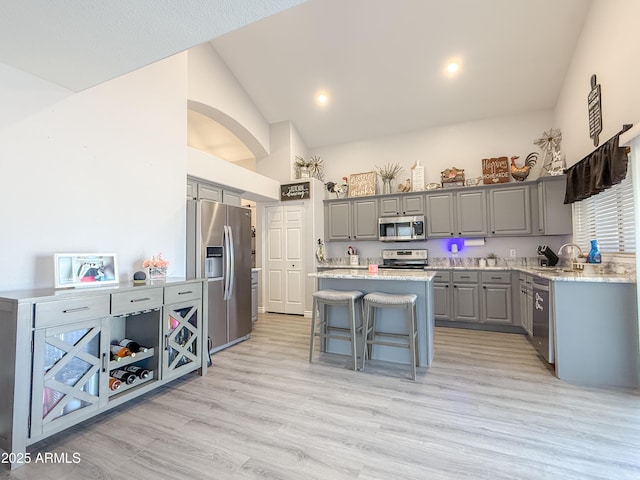 kitchen with a sink, stainless steel appliances, a kitchen island, and gray cabinets