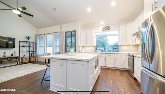 kitchen with white cabinets, a kitchen island, stainless steel appliances, tasteful backsplash, and dark hardwood / wood-style floors