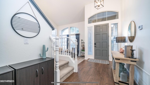 entrance foyer with dark hardwood / wood-style flooring and lofted ceiling