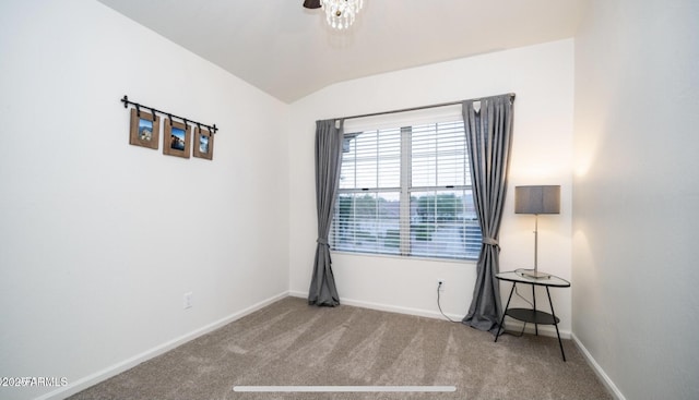 spare room featuring light carpet and vaulted ceiling