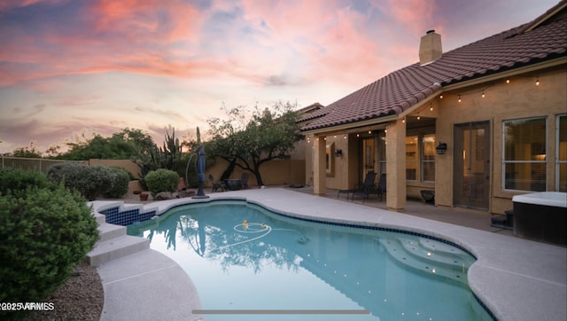 pool at dusk with a patio area