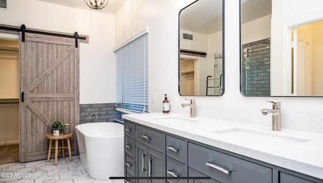 bathroom with tile patterned flooring, a bathtub, and vanity