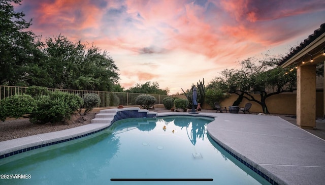 pool at dusk with a patio