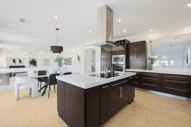 kitchen with island range hood, a kitchen island, dark brown cabinetry, pendant lighting, and stainless steel appliances