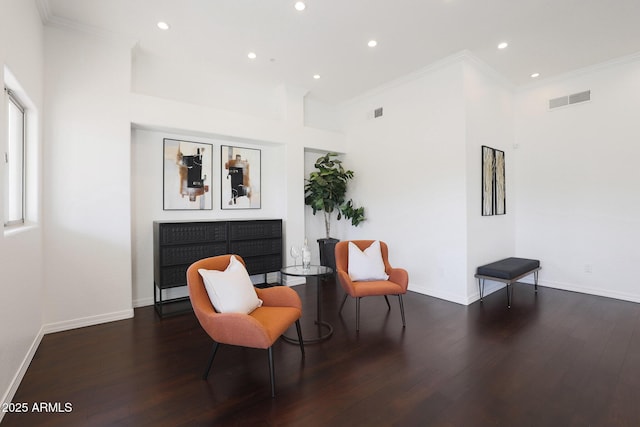 living area featuring crown molding and dark hardwood / wood-style floors