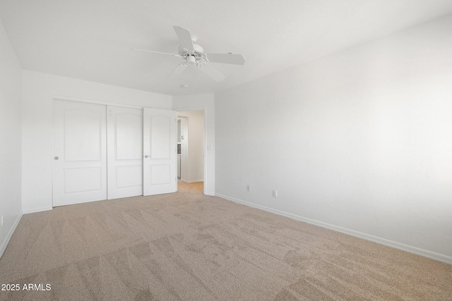 unfurnished bedroom with light colored carpet, a closet, and ceiling fan