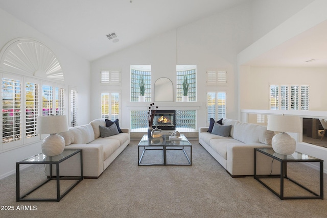 living room with light colored carpet and high vaulted ceiling