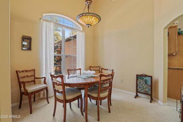 709 W Forest Dr, Payson, AZ 85541 - dining room featuring arched walkways, baseboards, and light colored carpet