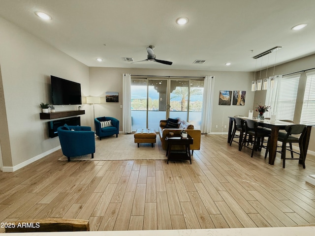living room featuring a wealth of natural light, recessed lighting, visible vents, and light wood-style floors