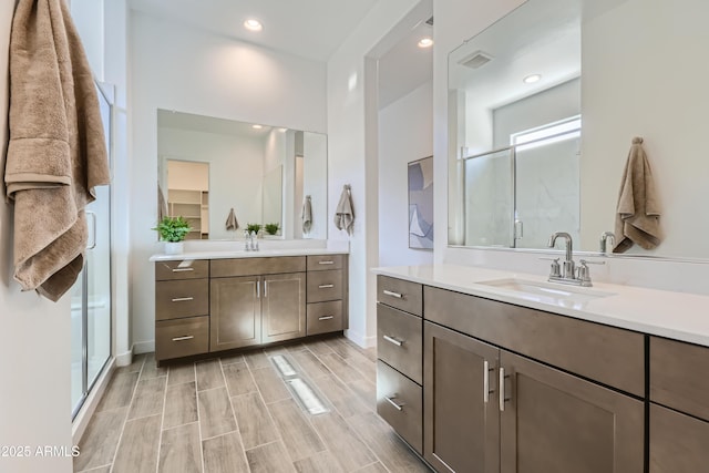 bathroom featuring wood finish floors, a stall shower, and a sink