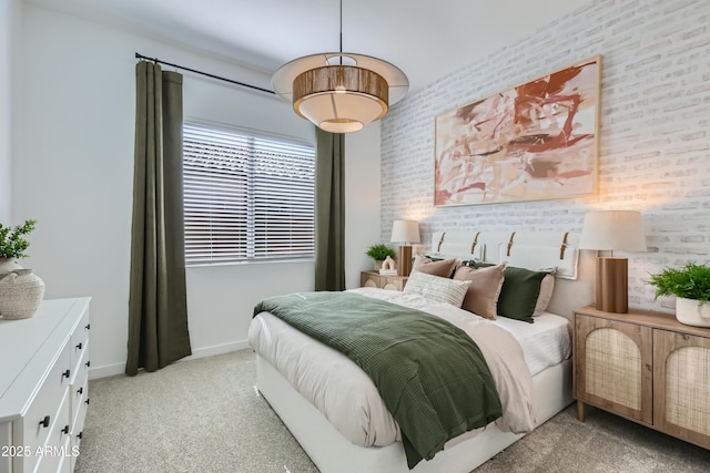 bedroom with light colored carpet, brick wall, and baseboards