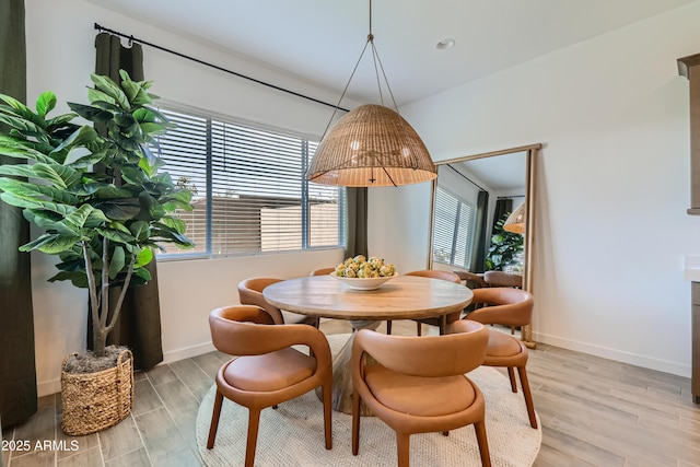 dining area featuring light wood-style flooring and baseboards