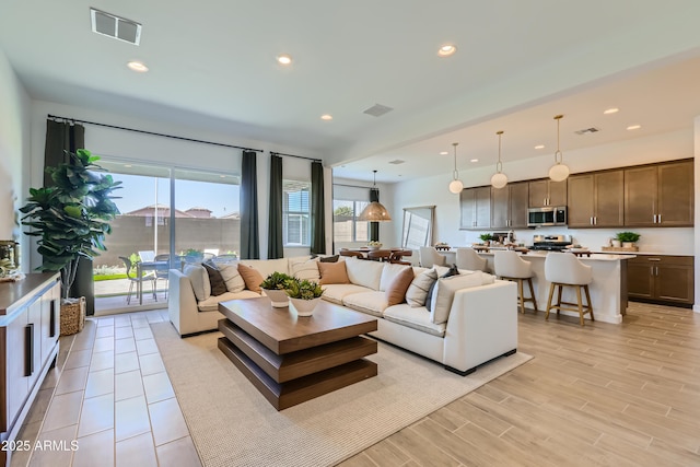 living area featuring recessed lighting, visible vents, and light wood-style flooring