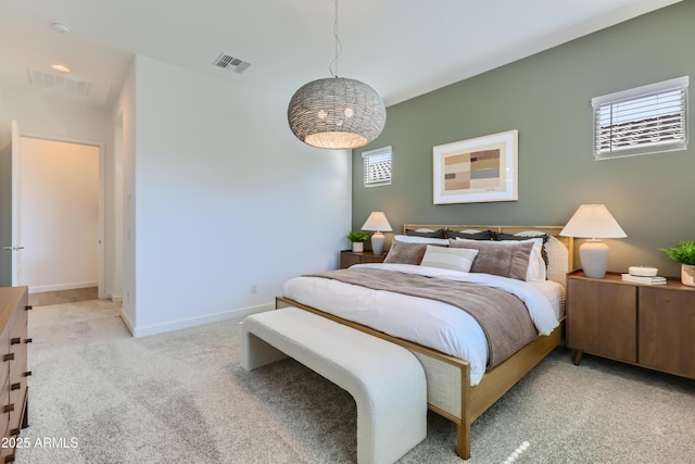 bedroom featuring visible vents, baseboards, and light carpet