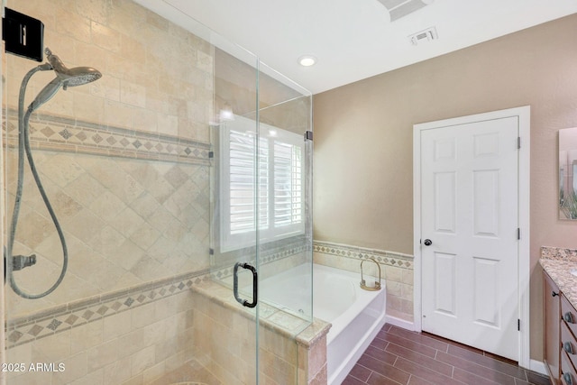 bathroom featuring vanity and independent shower and bath