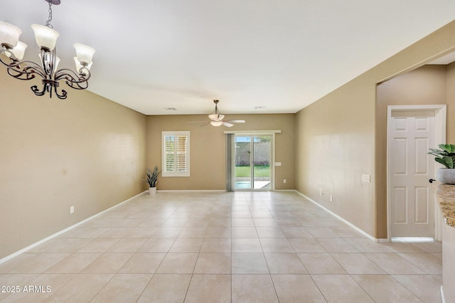 spare room featuring light tile patterned flooring and ceiling fan with notable chandelier