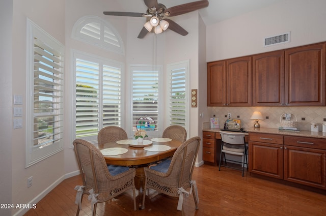 dining space with ceiling fan and light wood-type flooring