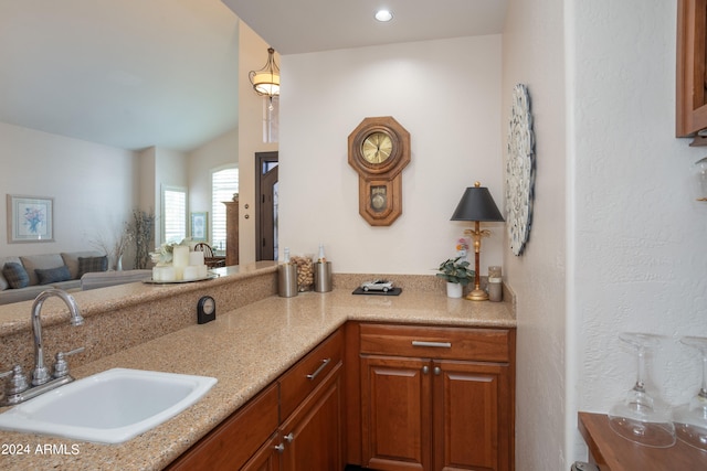 kitchen featuring light stone counters and sink