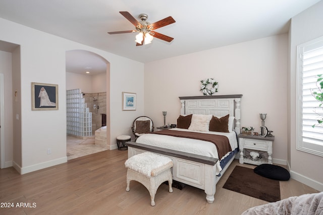 bedroom featuring connected bathroom, ceiling fan, and light wood-type flooring